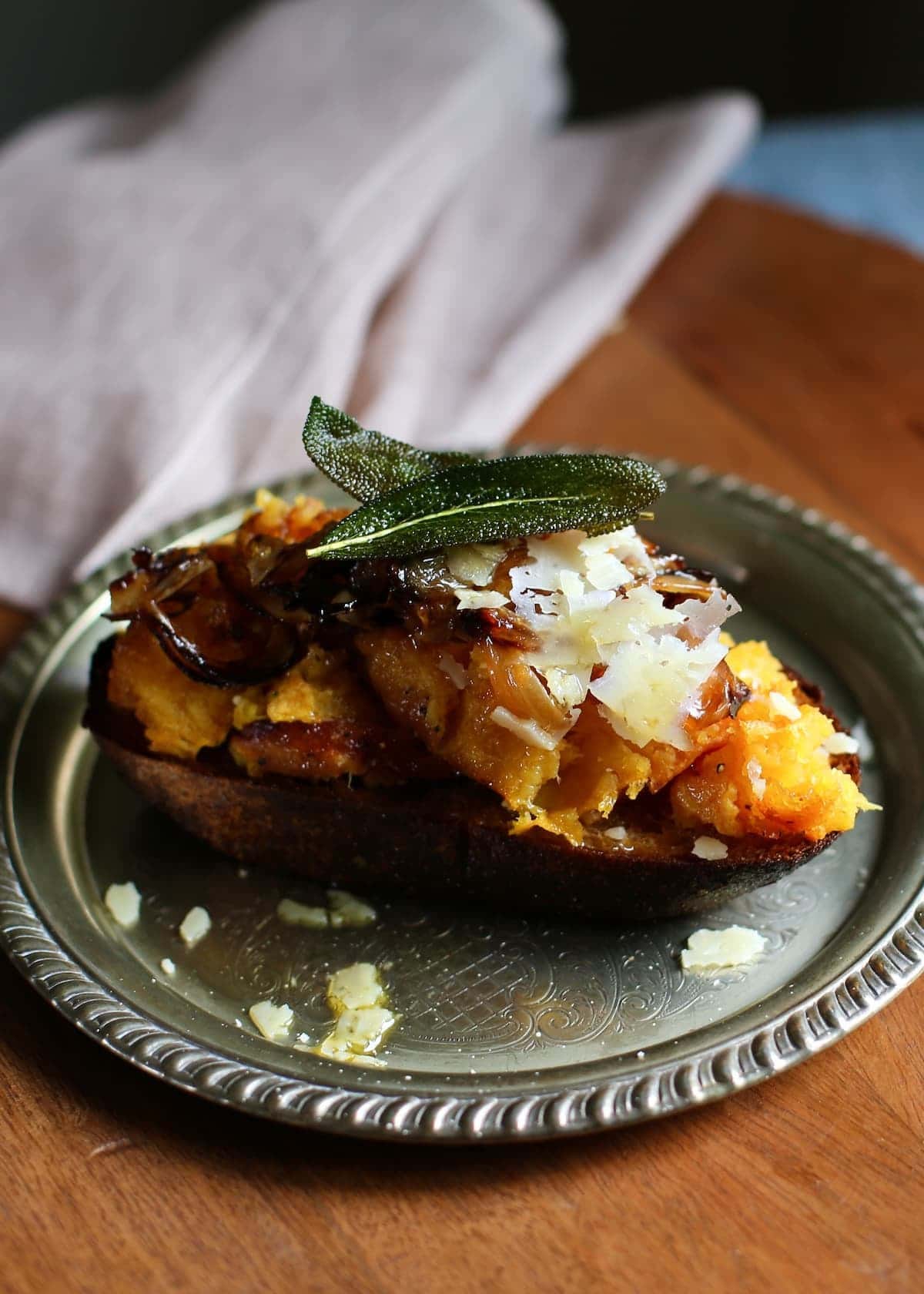 a squash toast on a silver plate on a wooden table.