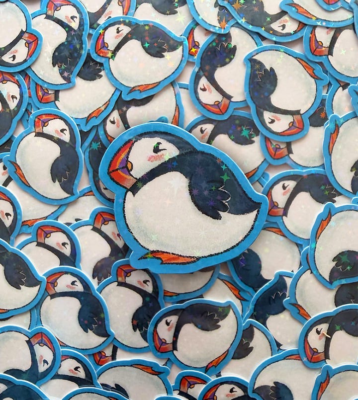 First photo: a sticker of a fat puffin.  Second photo: a hand painted ACEO of a dragon in a tea cup.