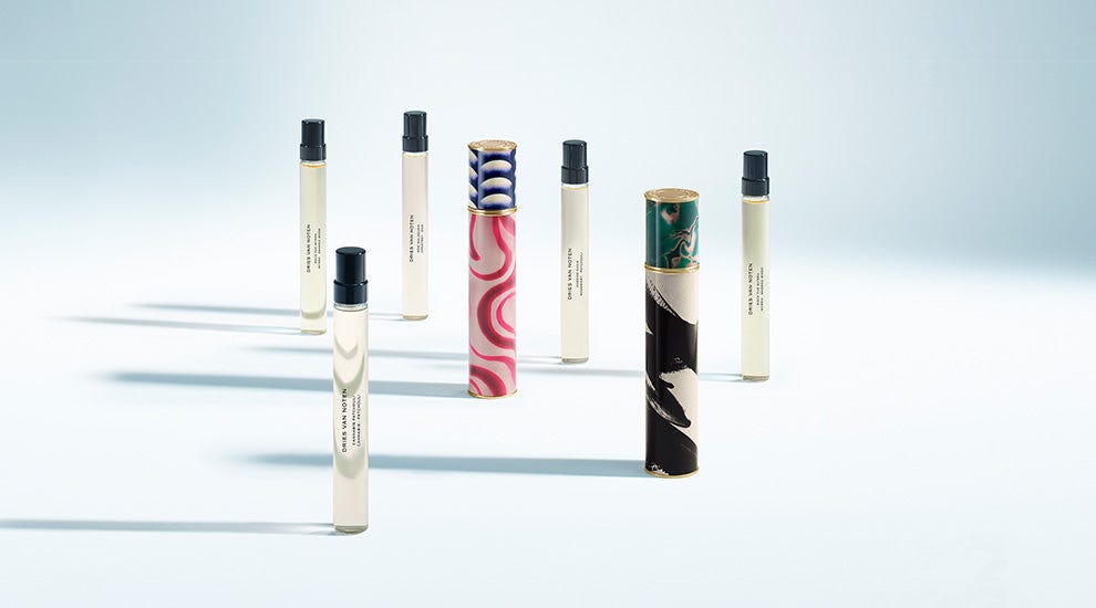 Set of small cylindrical beauty products with colorful designs on a light gray background - Dries Van Noten Set of small cylindrical beauty products with colorful designs on a light gray background - Dries Van Noten