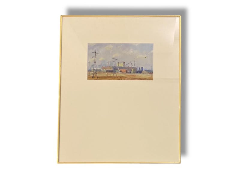 May include: A framed watercolor painting of a harbor scene. The artwork depicts a waterfront with cranes, buildings, and boats under a cloudy sky. The painting is set within a gold-colored frame, adding a touch of elegance to the artwork.
