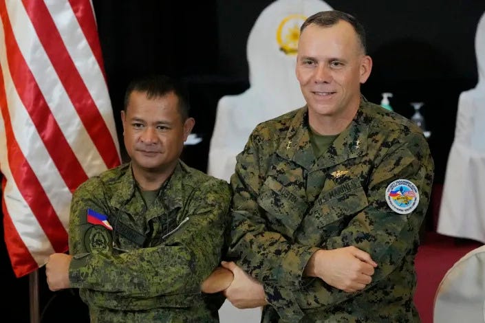 U.S. Marine Corps Major General Eric Austin, right, U.S. exercise director representative, and Philippine Army Major General Marvin Licudin, Philippine exercise director pose after the opening ceremonies of a joint military exercise flag called "Balikatan," a Tagalog word for "shoulder-to-shoulder," at Camp Aguinaldo military headquarters Tuesday, April 11, 2023, in Quezon City, Philippines. The United States and the Philippines on Tuesday launch their largest combat exercises in decades that will involve live-fire drills, including a boat-sinking rocket assault in waters across the South China Sea and the Taiwan Strait that will likely inflame China. (AP Photo/Aaron Favila)