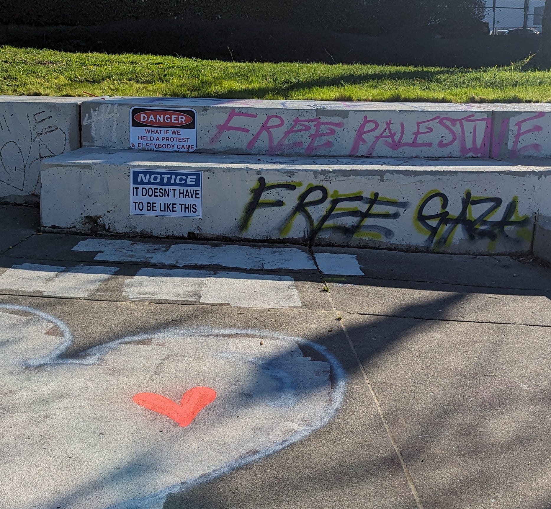 Concrete steps outside with "Notice" signs and graffit reading "Free Palestine" and "Free Gaza."