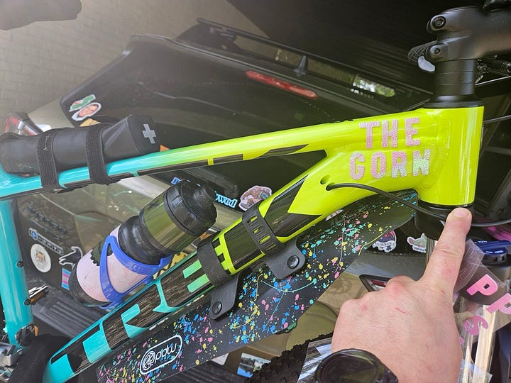 a green and yellow mountain bike emblazoned with "The Gorn" in pink fluffy letters on the frame.