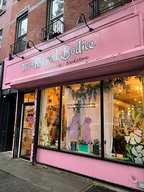 left: the outside of the Ripped Bodice Bookstore in Brooklyn with its iconic pink exterior; center: Rachel in conversation with Jessica Saunders; right: Rachel seated and holding up a copy of WHIA and me standing next to her posing for a picture
