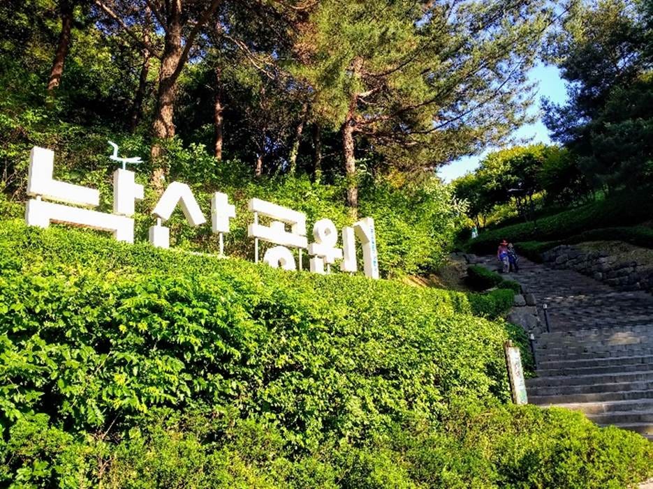 A sign on a hill with trees and stairs

AI-generated content may be incorrect.