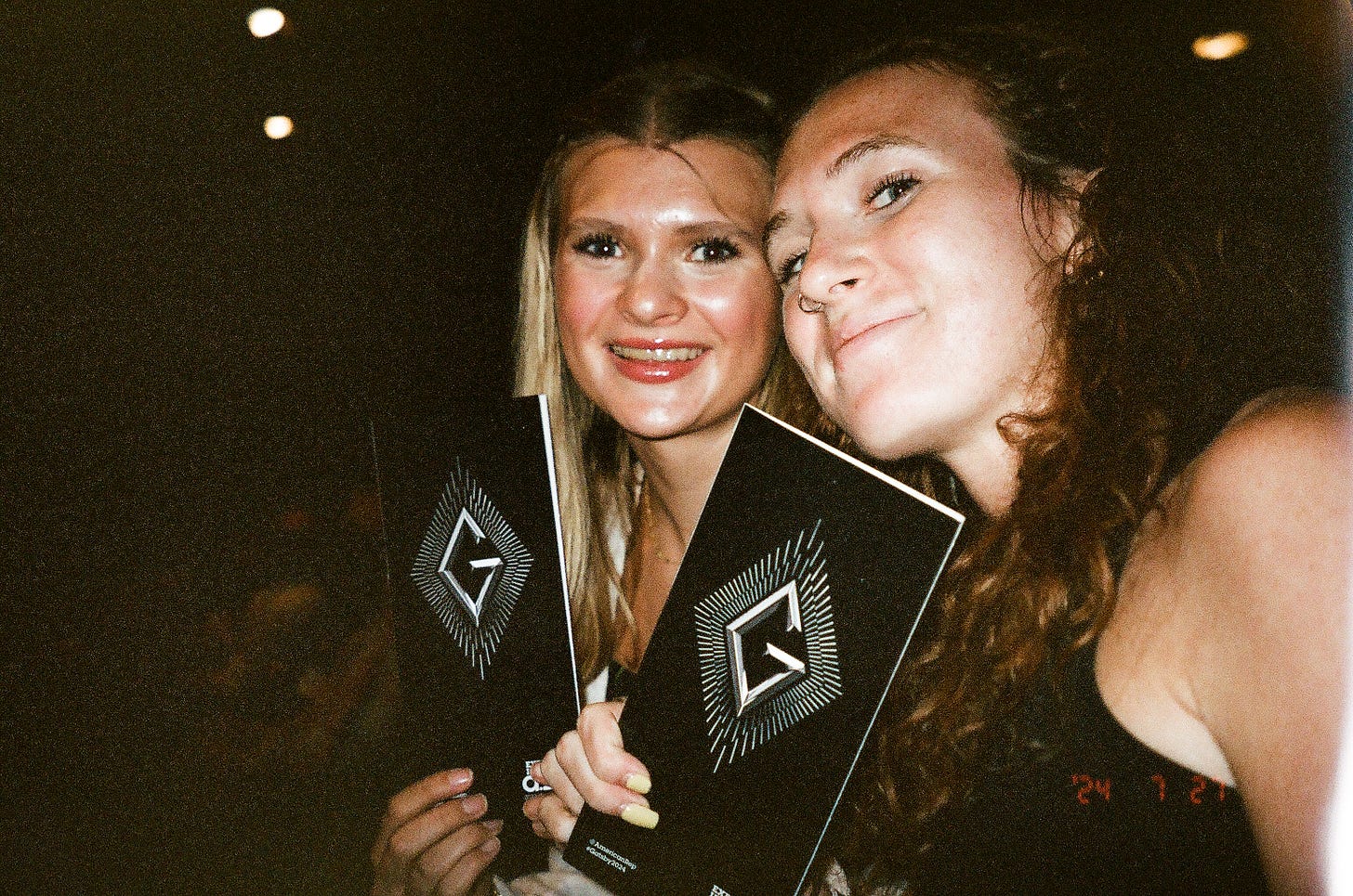 Two girls smiling holding up playbills. Two girls smiling holding up playbills.