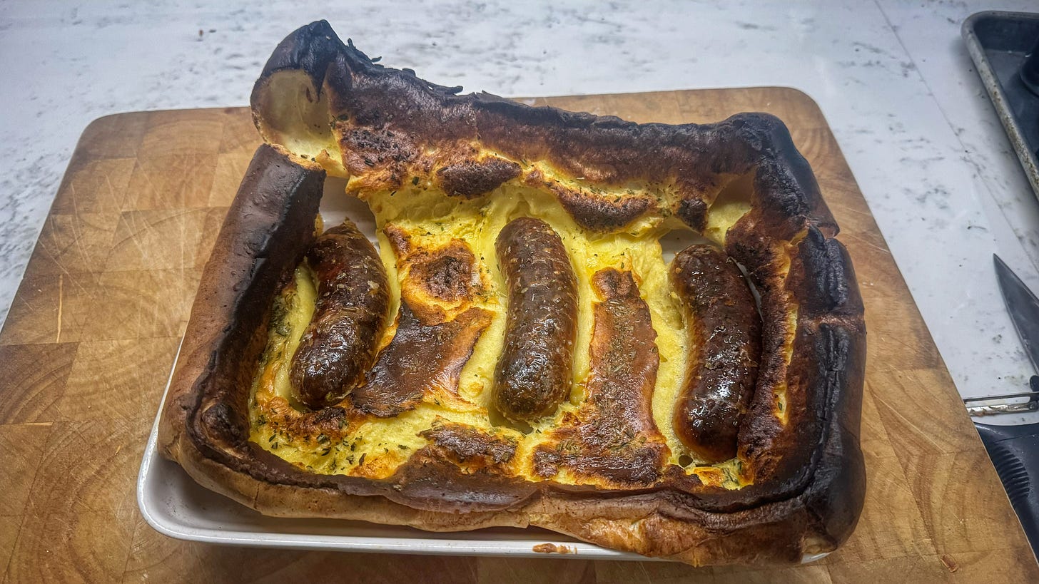 A finished Toad in the Hole. The batter has risen very high and burned in parts. 