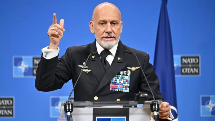 L'ammiraglio Giuseppe Cavo Dragone parla a un podio durante una conferenza stampa della Nato, gesticolando con la mano destra alzata.