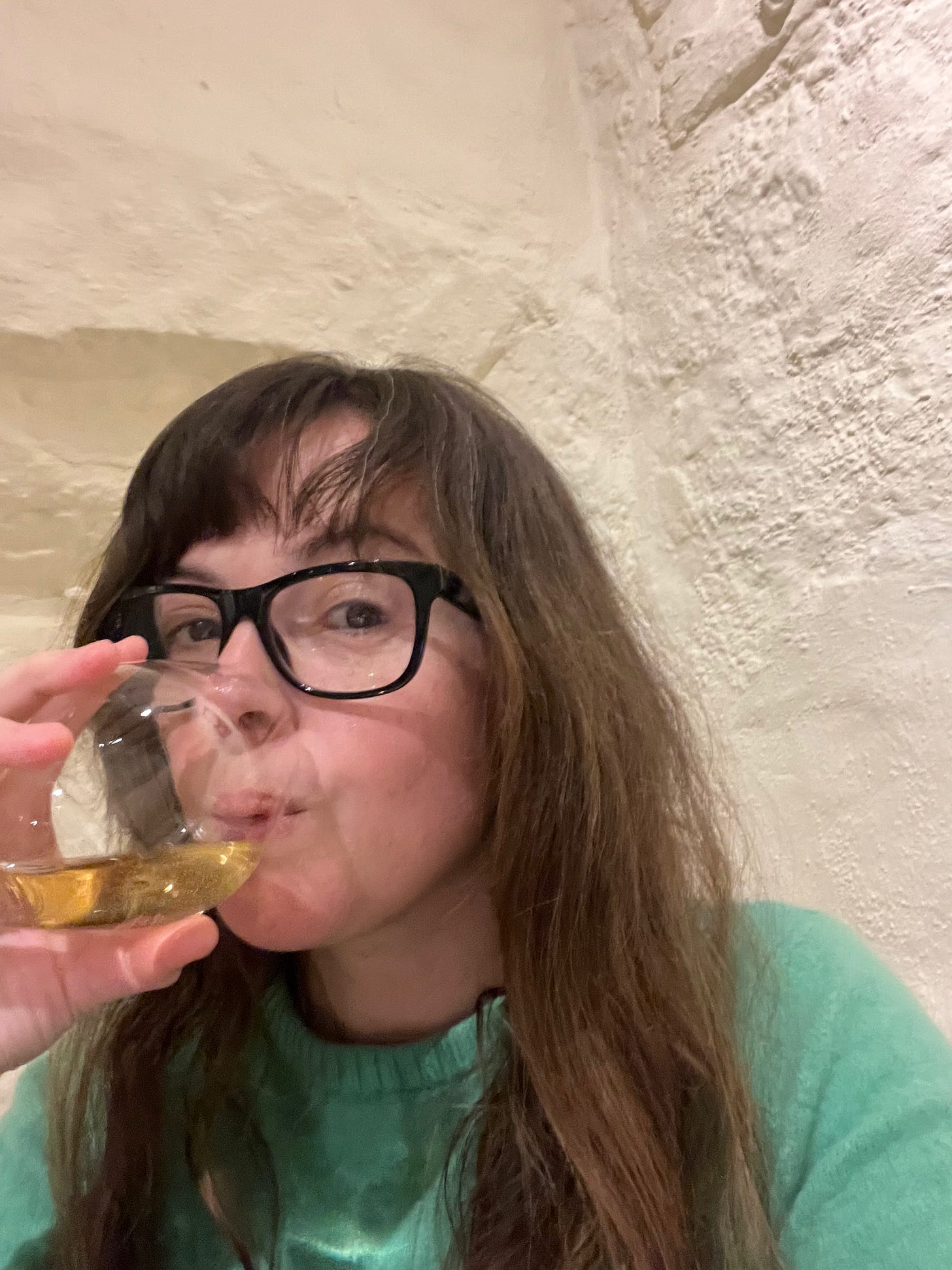 Claire drinking wine in a restaurant