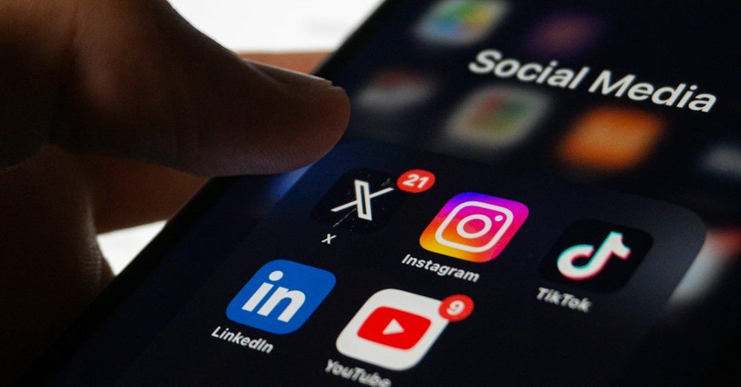 A person holding a smart phone with social media on the screen