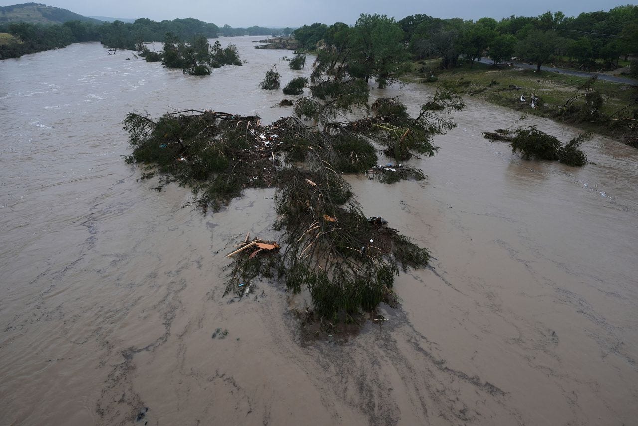 A flooding Guadalupe River leaves fallen trees and debris in its wake, in Kerrville, Texas, on Friday.
