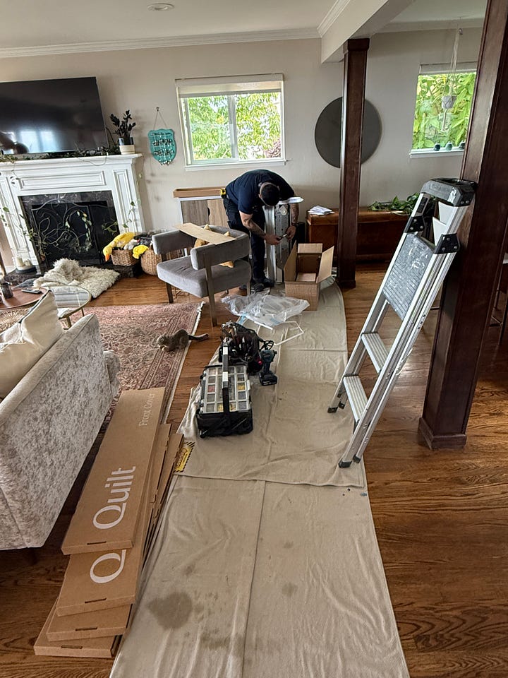 A gallery of photos showing Quilt branded boxes, a worker, ladder, and tools, plus floor covering in the main room, and a photo of a wall showing a white mini-split above a bar cabinet.