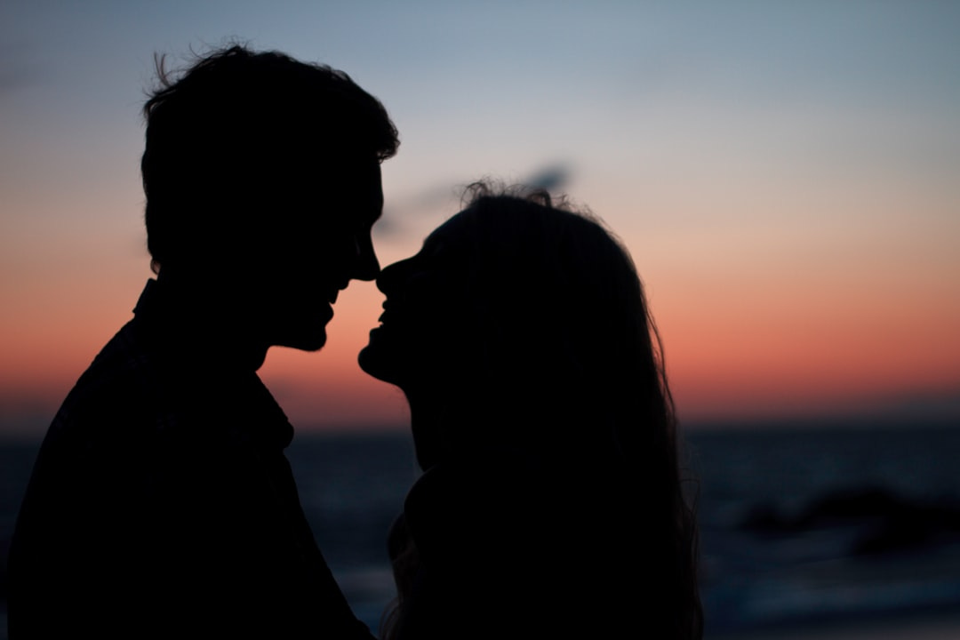 silhouette of man and woman about to kiss on beach during sunset silhouette of man and woman about to kiss on beach during sunset