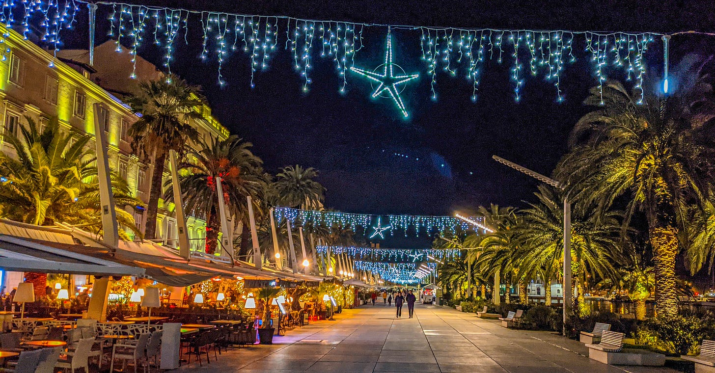 Blue icicle Christmas lights and stars hang over Split's Riva. 