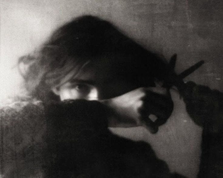 This may contain: a black and white photo of a woman holding scissors