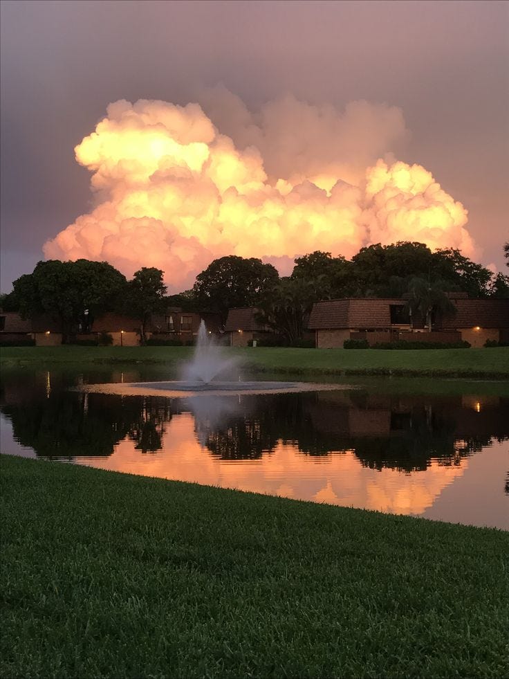 This may contain: a fire hydrant spewing out water in front of a large cloud filled sky