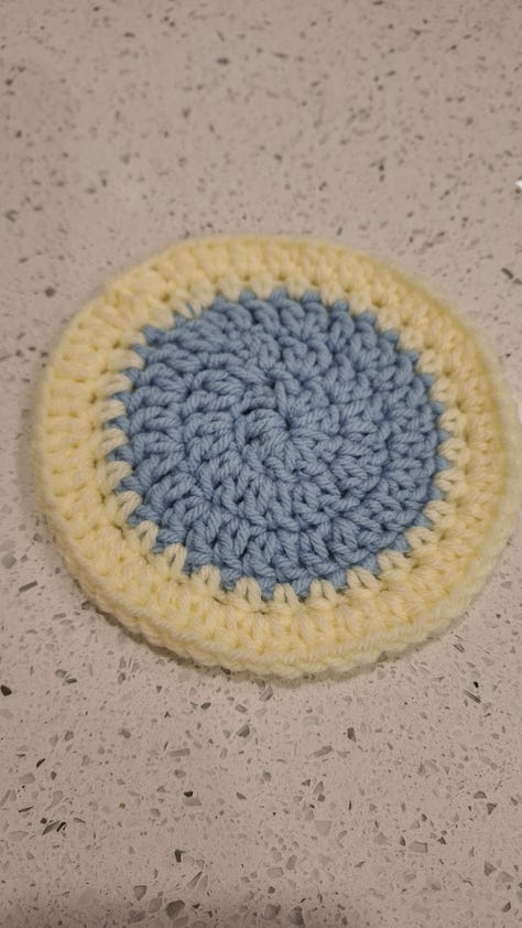 yellow bookmark, pile of crocheted items, rainbow book cozy, yellow pocket, blue coaster, set of pockets