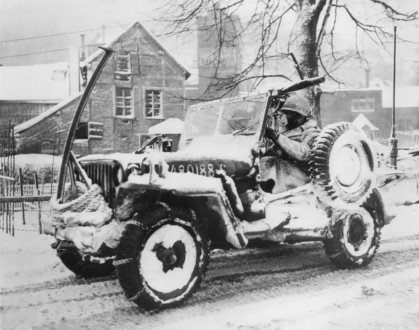 A 30th Infantry Division Willys jeep in Malmedy, Belgium, January 27, 1945, notably equipped with a vertical bar modification on the bumper designed to counter German wire booby traps.