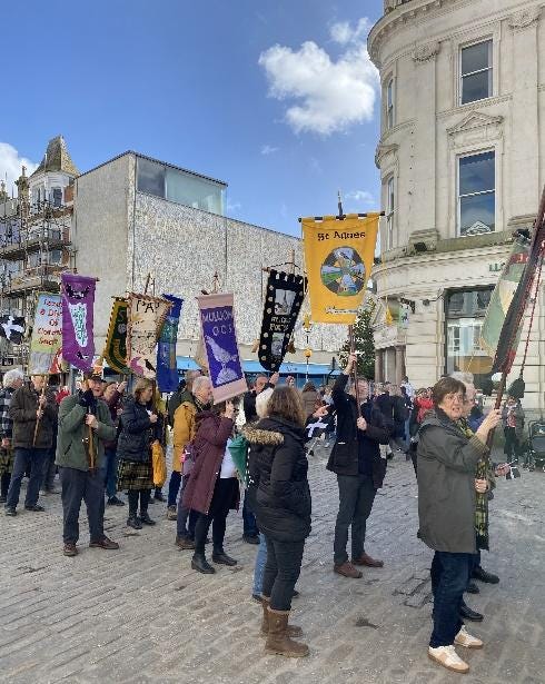 A group of people holding banners

Description automatically generated