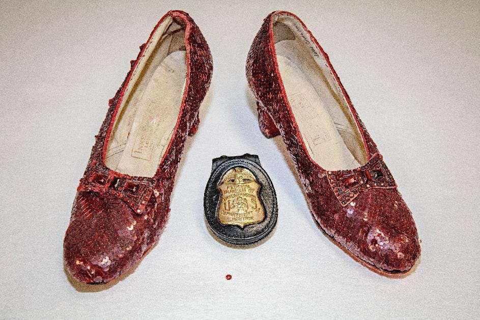 a pair of ruby slippers on a table with a red sequin and a police badge