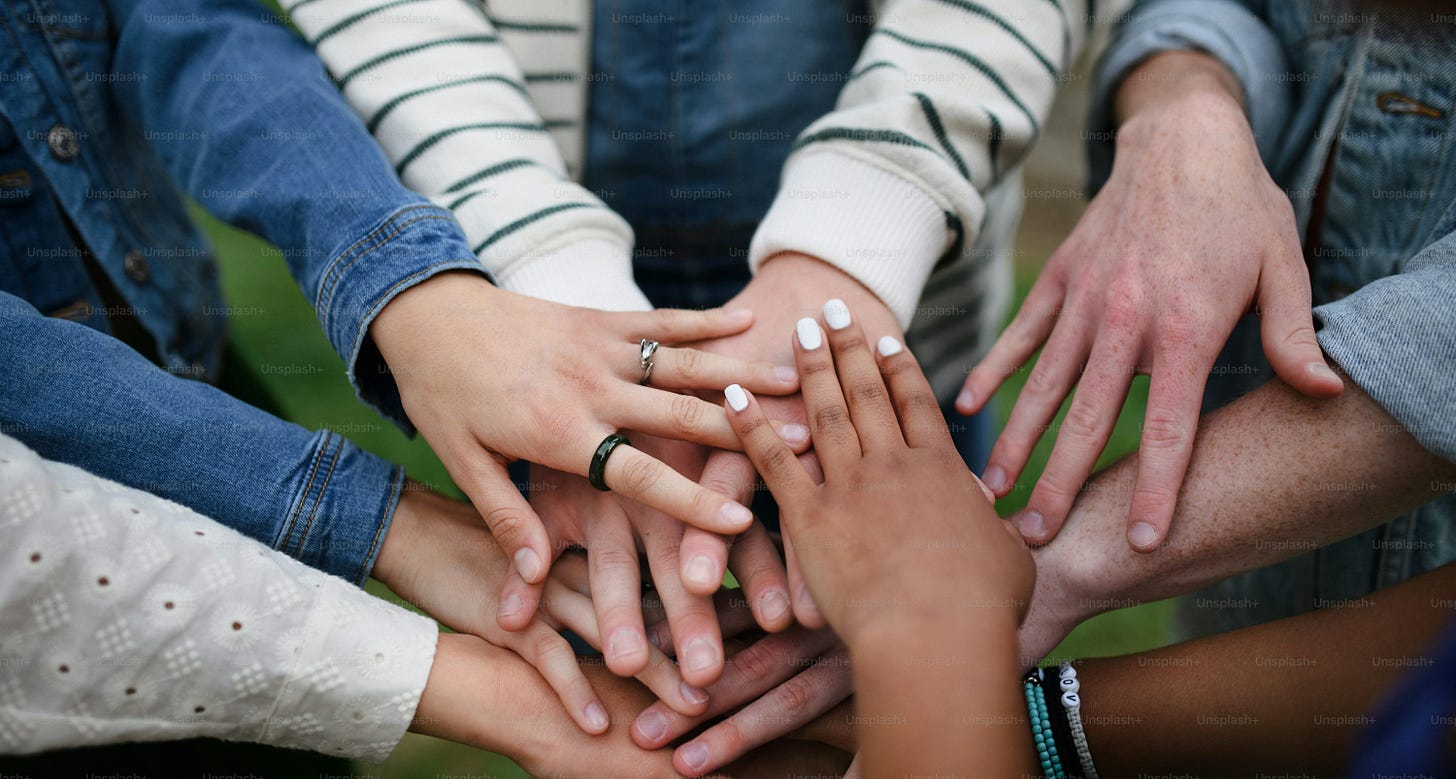 A close-up of diverse group of friends stacking their hands together in circle, Friendship and lifestyle concepts A close-up of diverse group of friends stacking their hands together in circle, Friendship and lifestyle concepts