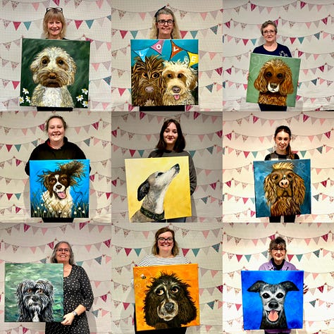 Students holding their paintings of their cats and dogs