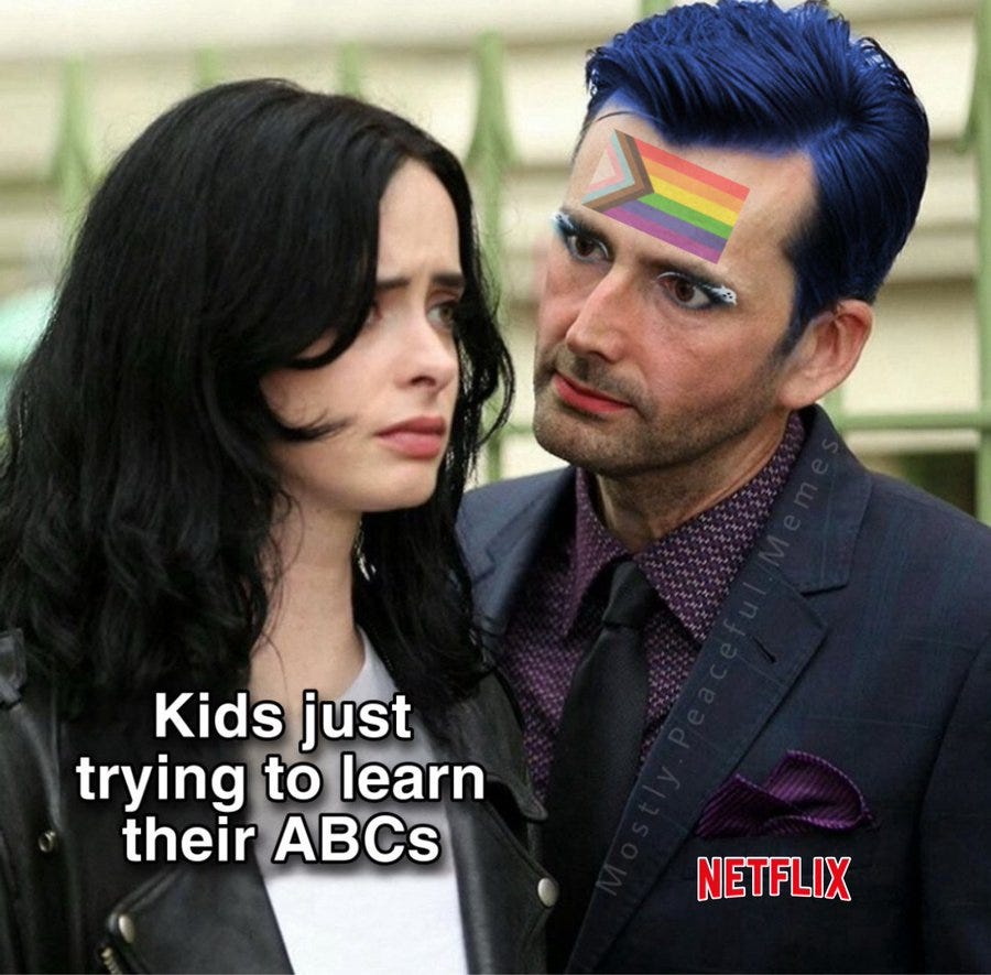 Kristen Stewart with long black hair wearing a black leather jacket, standing next to a man with blue hair and a rainbow flag design on his forehead, wearing a dark suit and patterned shirt. Text overlay reads "Kids just wanting to learn their ABCs" and a Netflix watermark is visible.