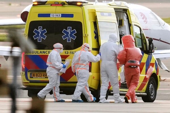 Medics escort a patient, second right, evacuated from the MV Hondius cruise ship with suspected hantavirus infection, to an ambulance after being flown to Schiphol airport, Amsterdam, Netherlands, Wednesday, May 6, 2026. (AP Photo/Peter Dejong)