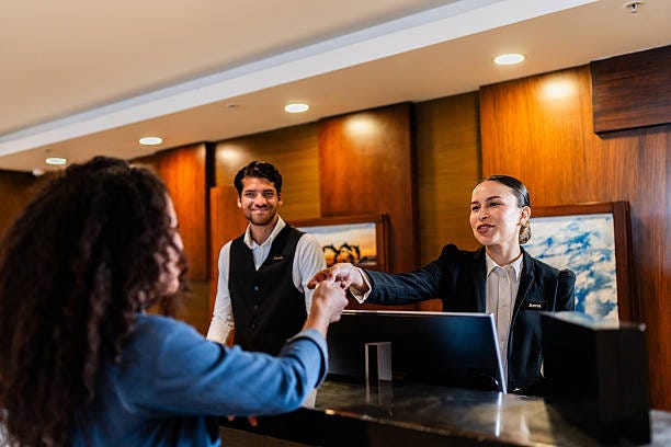 Young receptionist woman giving key card to guest at hotel Young receptionist woman giving key card to guest at hotel front desk of hotel stock pictures, royalty-free photos & images