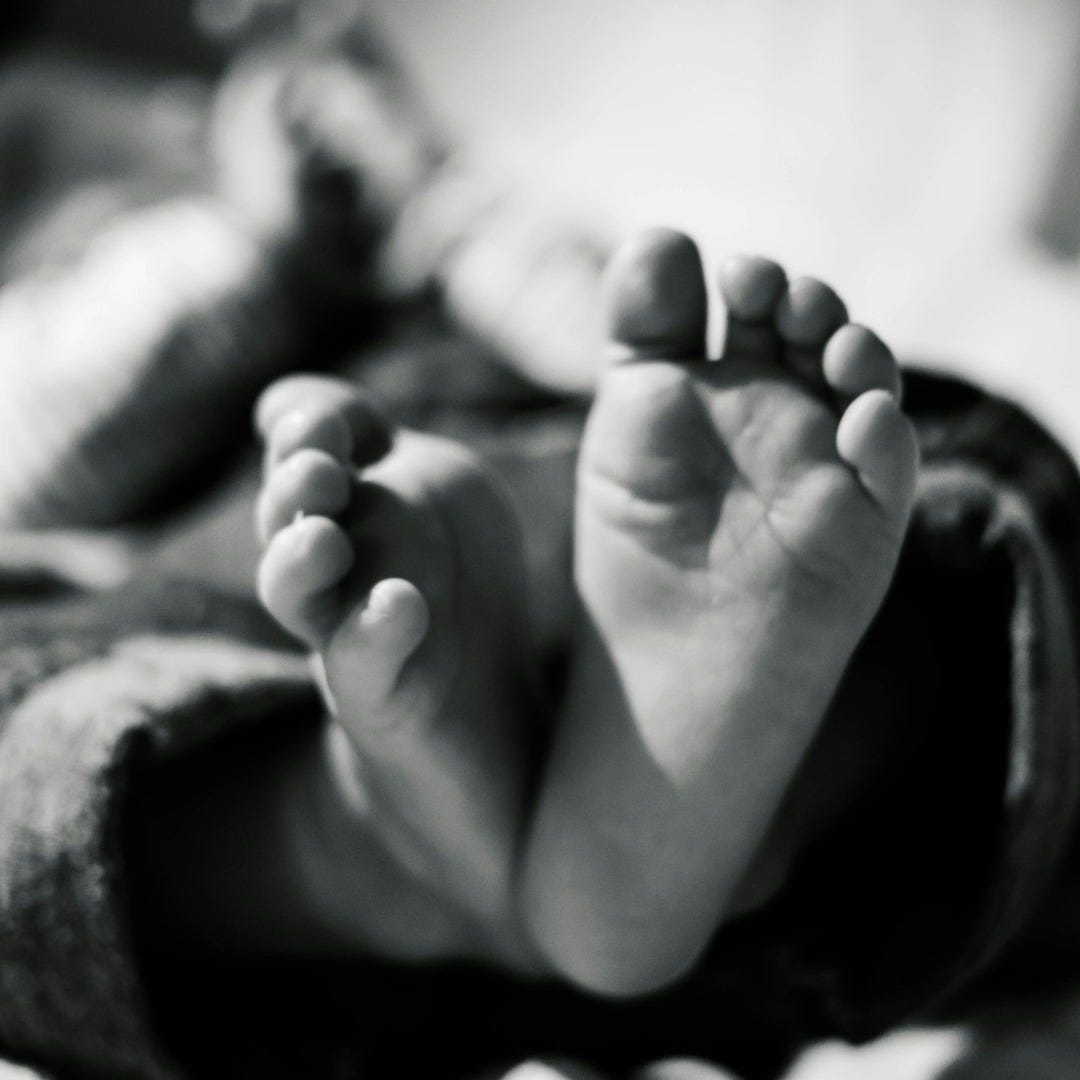 grayscale photo of baby's feet grayscale photo of baby's feet