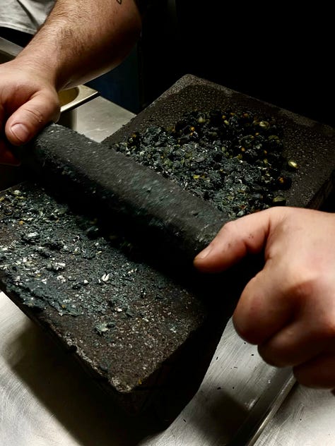 Corn being ground my hand on stone