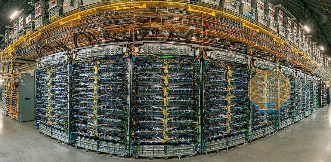 A fisheye view of a data center wall with rows of server racks, complex cabling and overhead cable trays. A fisheye view of a data center wall with rows of server racks, complex cabling and overhead cable trays.