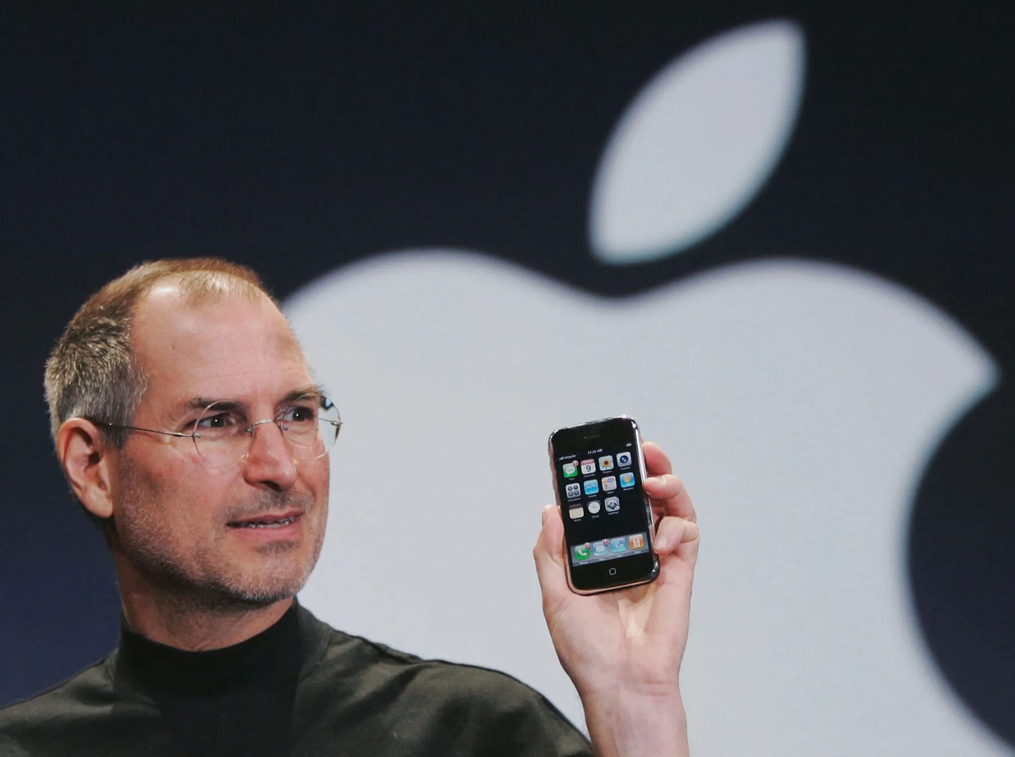 Tech leader holding up the first iPhone during a product launch, symbolizing product risk removal and proof of innovation.