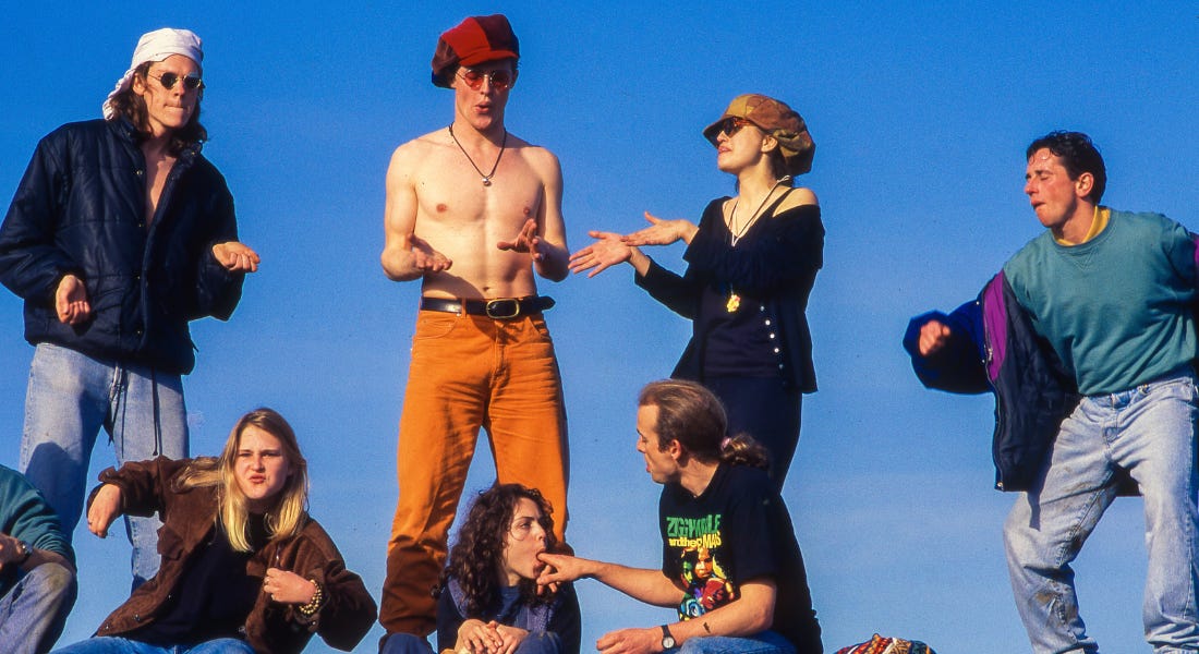 A group of people raving in colourful outfits against a blue sky