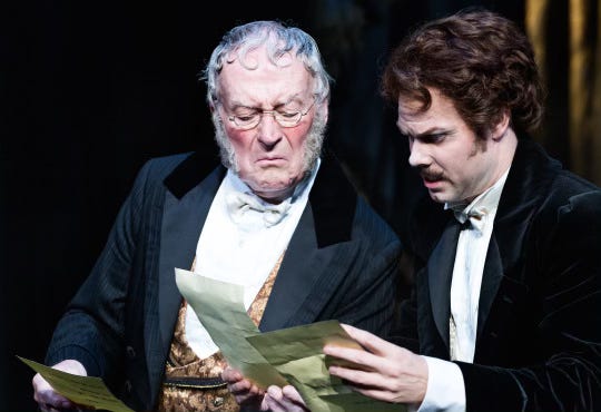 2 men in period evening clothes look upset with th evil they hold in their hands 2 men in period evening clothes look upset with th evil they hold in their hands