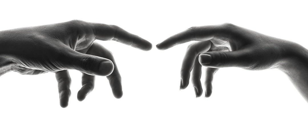 two person's connecting fingers