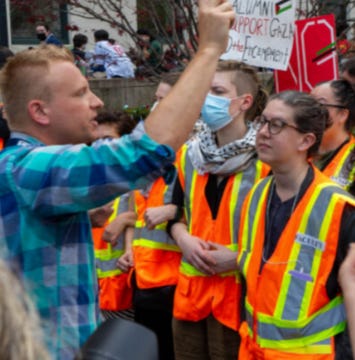 First image shows a middle-aged woman with shoulder-length gray hair, wearing clear-framed glasses, red lipstick, silver hoop earrings, and a black and white patterned open cardigan over a dark top, smiling slightly against a beige brick wall. Second image depicts a group of protesters at an outdoor rally near trees, wearing orange safety vests and holding red signs reading Support Gaza, No War on Gaza, and End the Genocide; a man in a blue plaid shirt raises his arm, surrounded by diverse individuals including some in keffiyehs and masks.