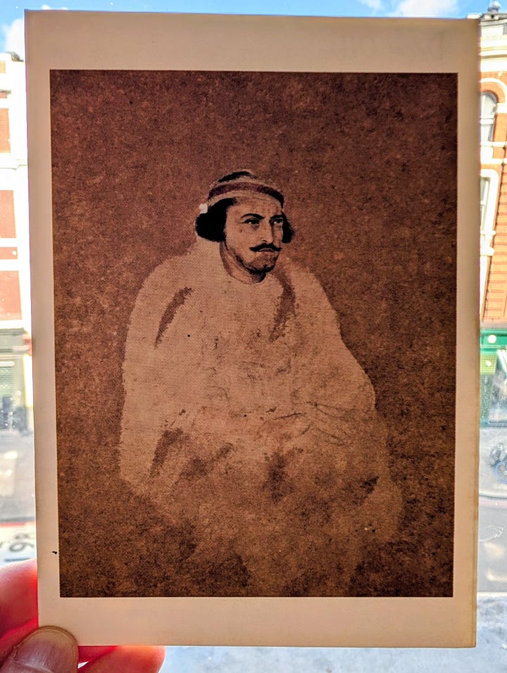A sepia-toned watercolour and pencil portrait of a seated man wrapped in a shawl, wearing a hat. A hand holds open pages of a handwritten letter in blue ink, with a London street of brick buildings visible through a window behind.
