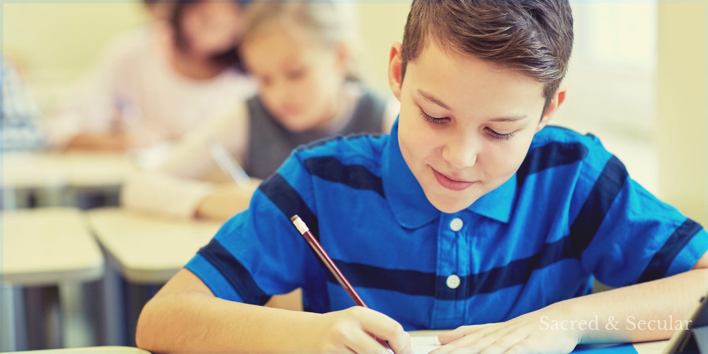 A child writing with a pencil in a classroom. A child writing with a pencil in a classroom.