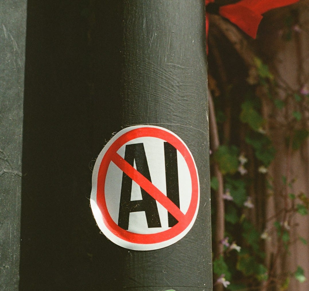 No ai! sticker on a dark pole with green advertisement.