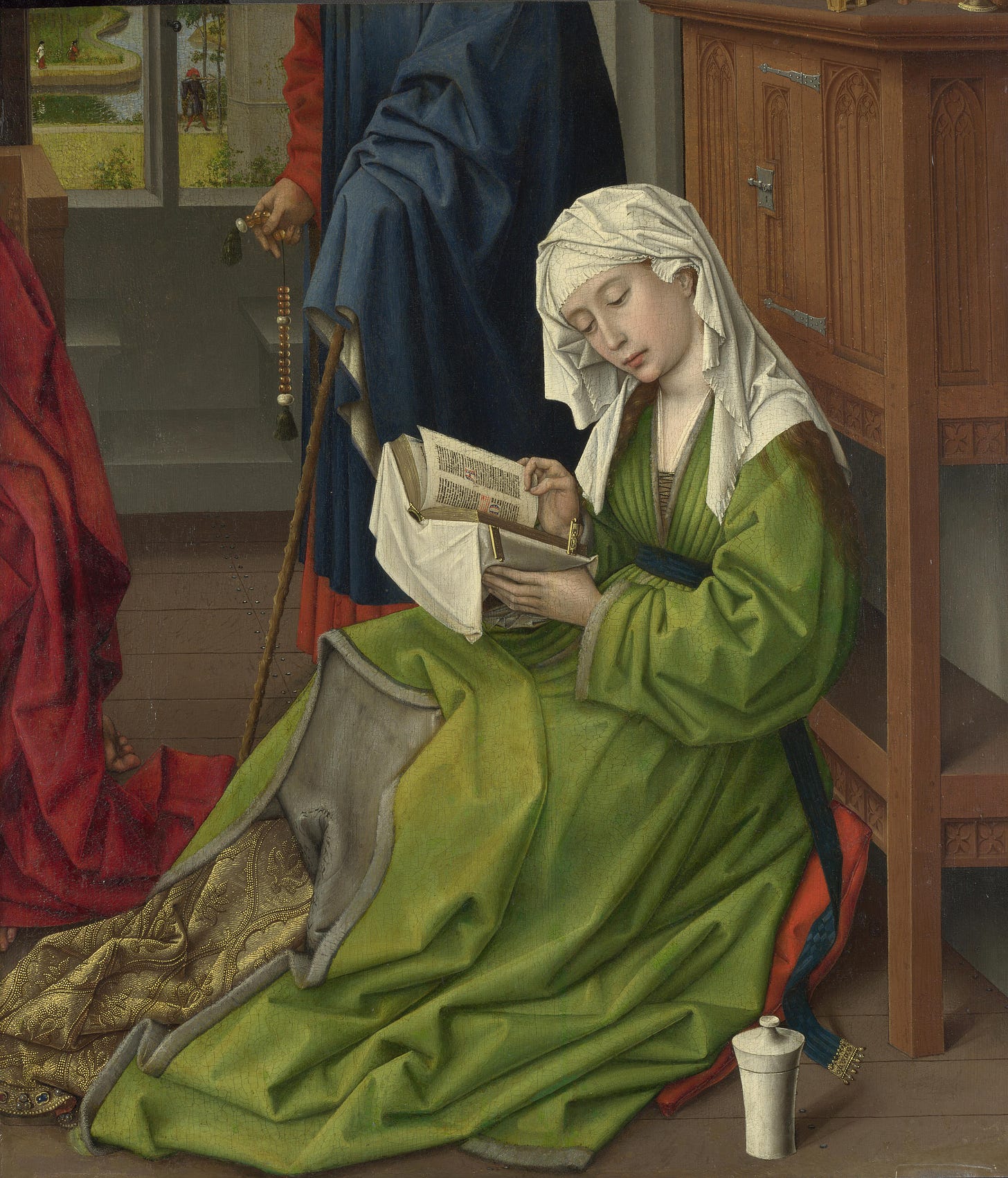 Woman in green reading a book on the floor Woman in green reading a book on the floor