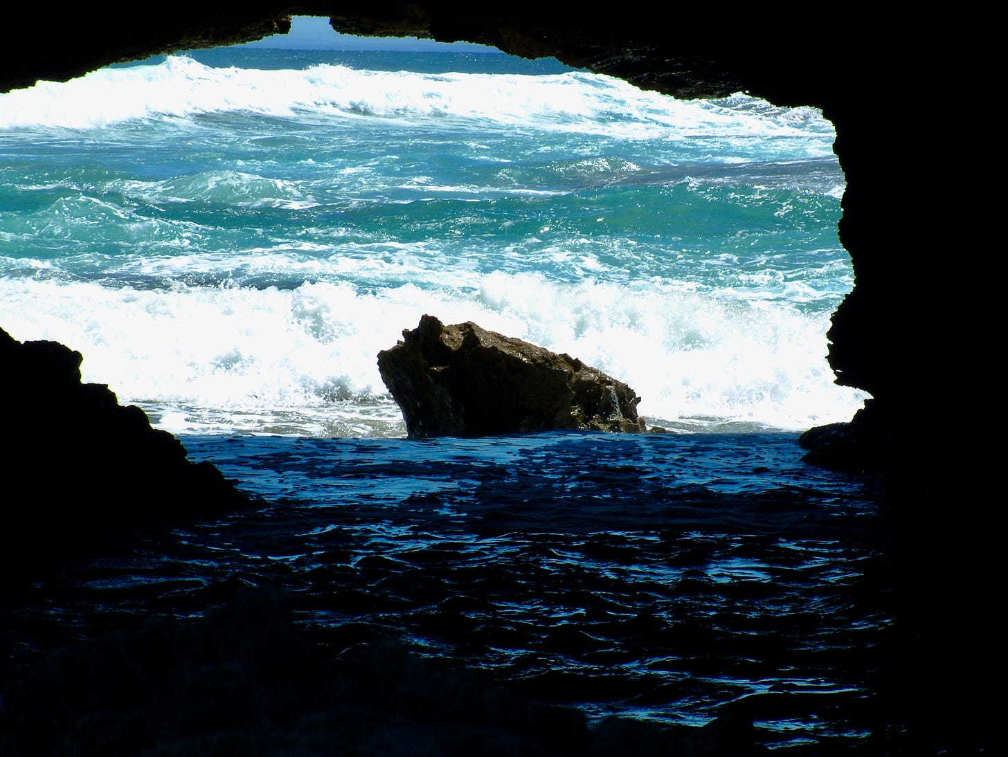 Boiling surf viewed from inside a dark cave