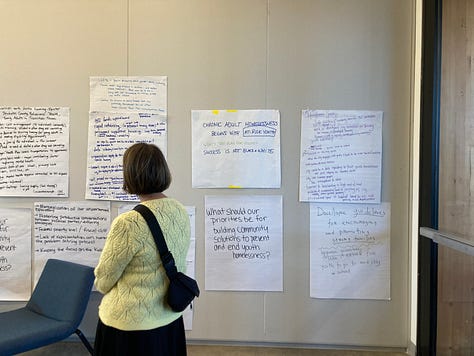 First two photos include Deschutes assembly members deliberating in small groups, and the third photo has a women looking at a wall with priorities that have been written up.