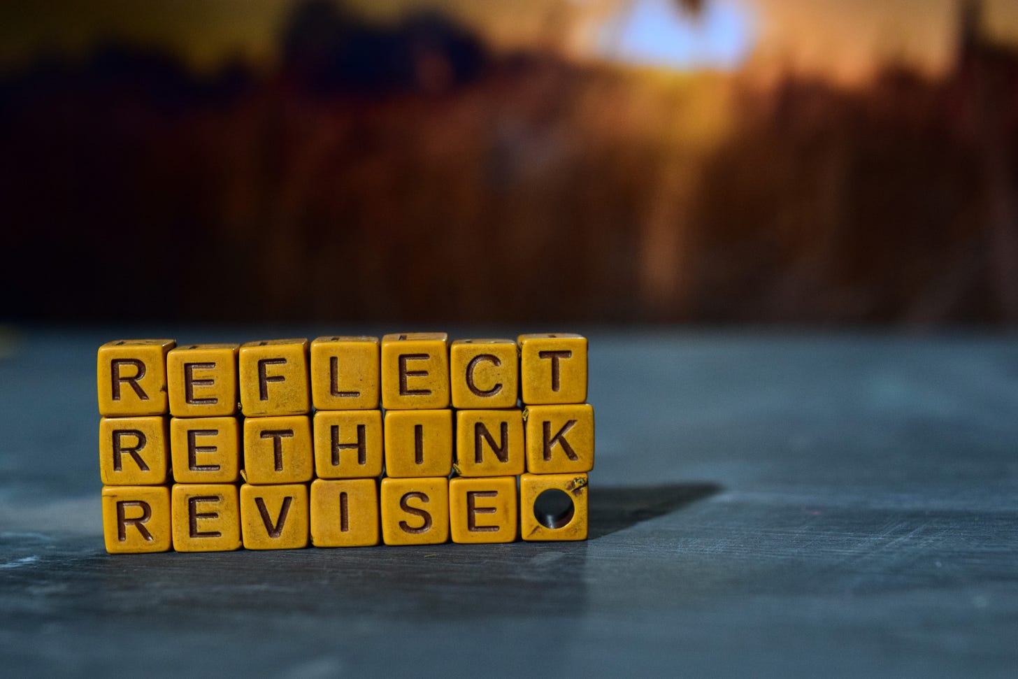 Yellow letter blocks spelling “Reflect, Rethink, Revise,” set against a blurred background, suggesting thoughtful self-assessment and renewal. Yellow letter blocks spelling “Reflect, Rethink, Revise,” set against a blurred background, suggesting thoughtful self-assessment and renewal.
