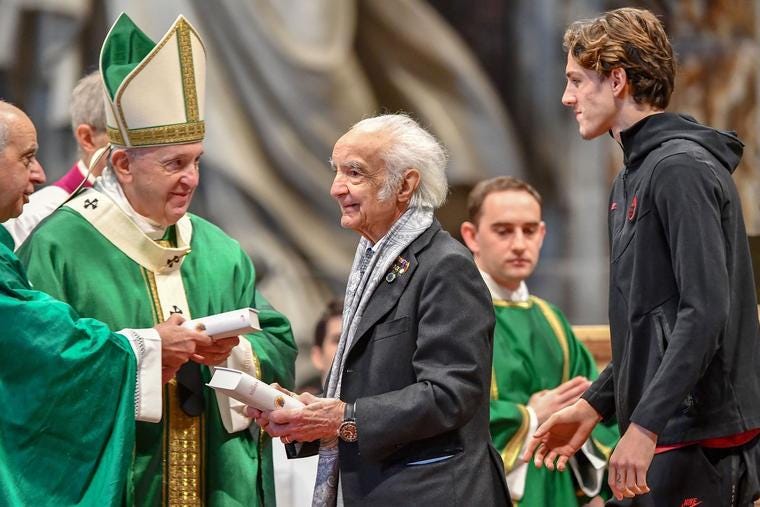 Italian physicist Antonino Zichichi (c) holds a Bible he just received from Pope Francis (l) as Italian football midfielder Nicolò Zaniolo (r) waits to receive his Bible during a Sunday of the Word of God Mass on Jan. 26, 2020, at St. Peter's Basilica in the Vatican.