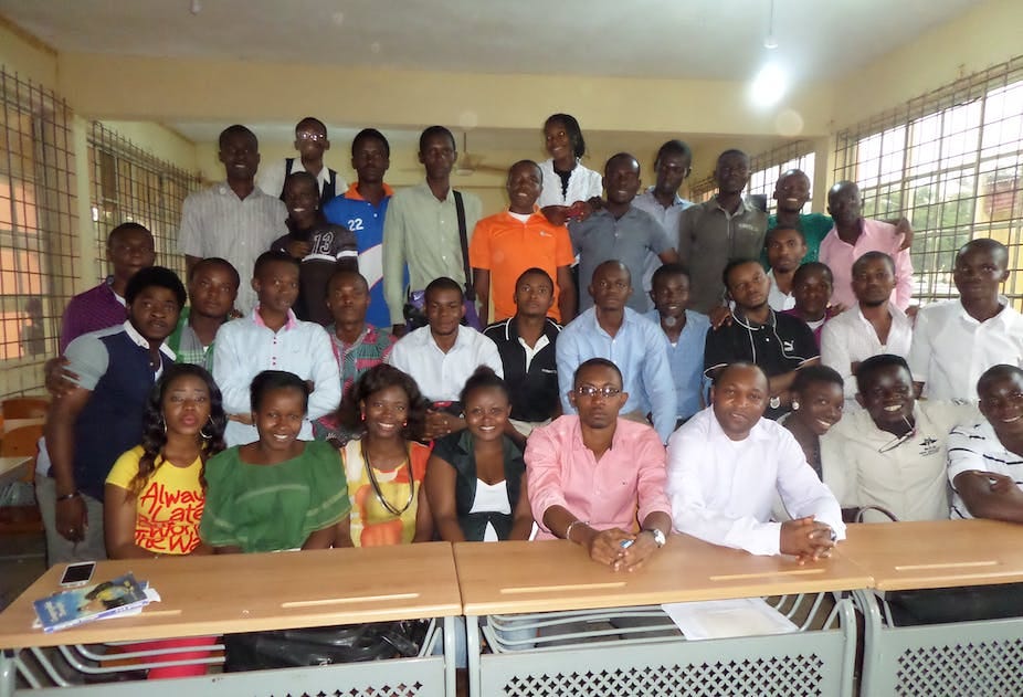 A group of students pose for a photograph in a classroom A group of students pose for a photograph in a classroom