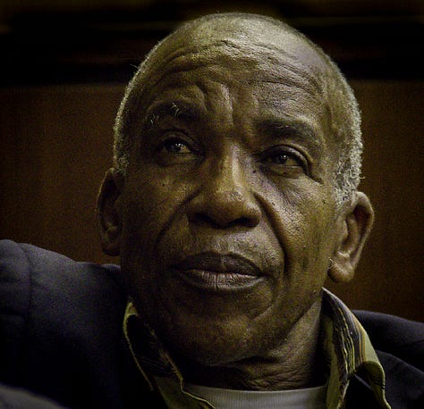 An old white man with a hard face, the face of an askari, a turned guerrilla, and a former Security Police explosives expert