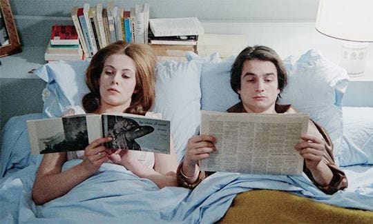 Jean-Pierre Léaud and Claude Jade laying in bed, reading