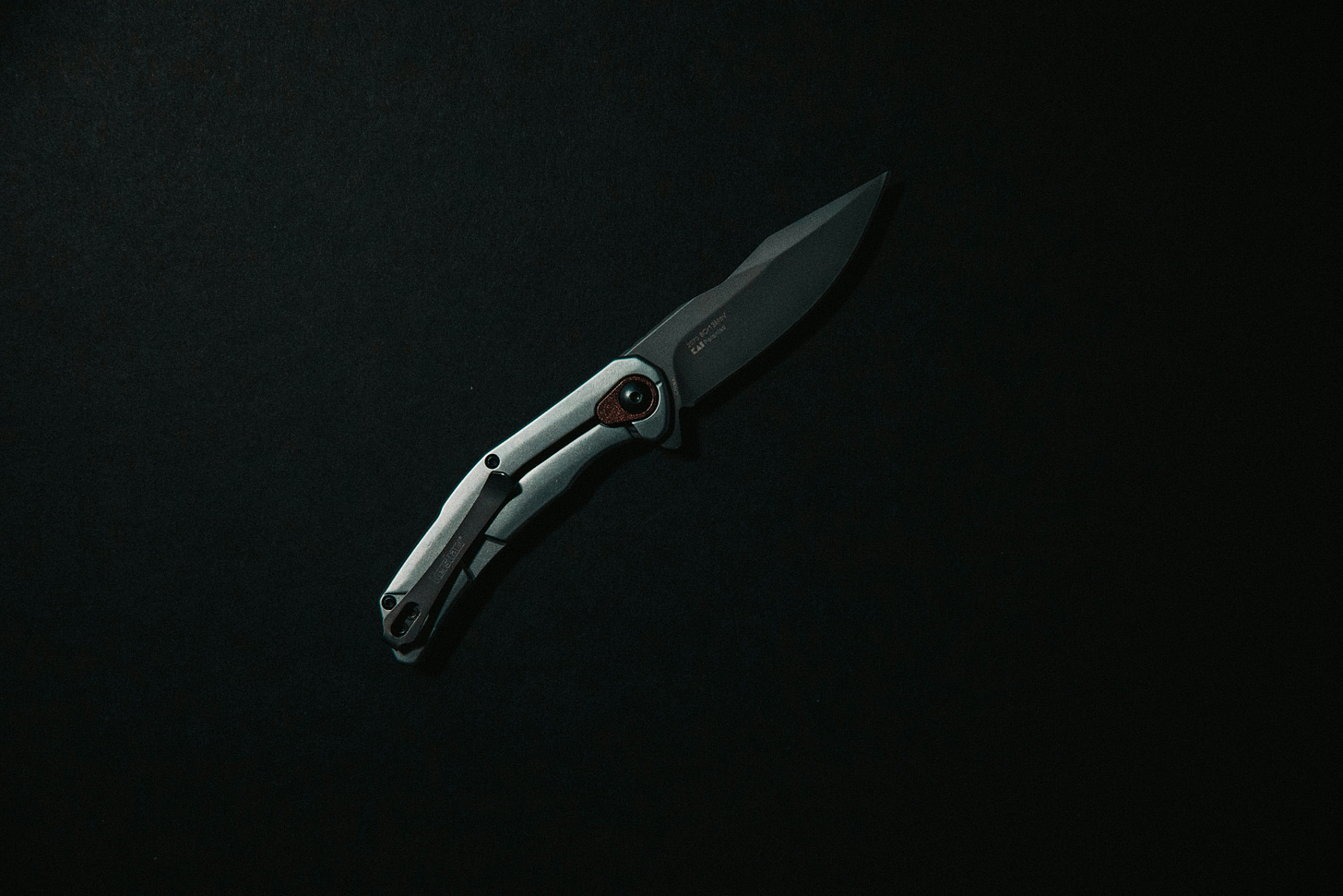 A silver knife on a black background. 