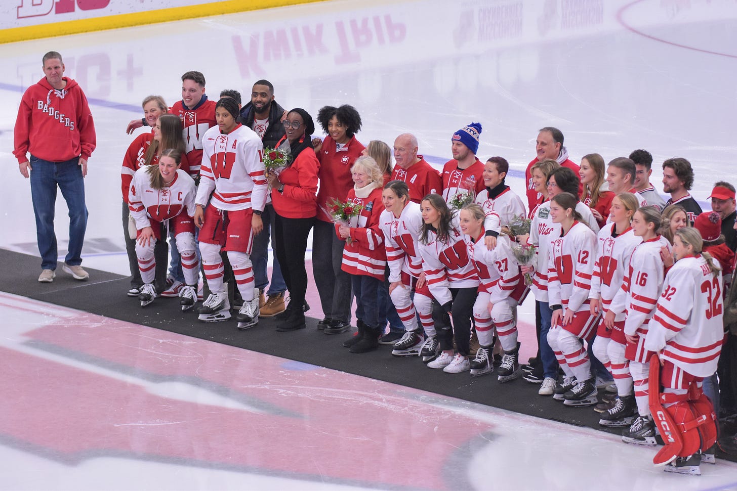 Wisconsin Badgers players and their family members line up for a photo at center ice of LaBahn Arena Wisconsin Badgers players and their family members line up for a photo at center ice of LaBahn Arena